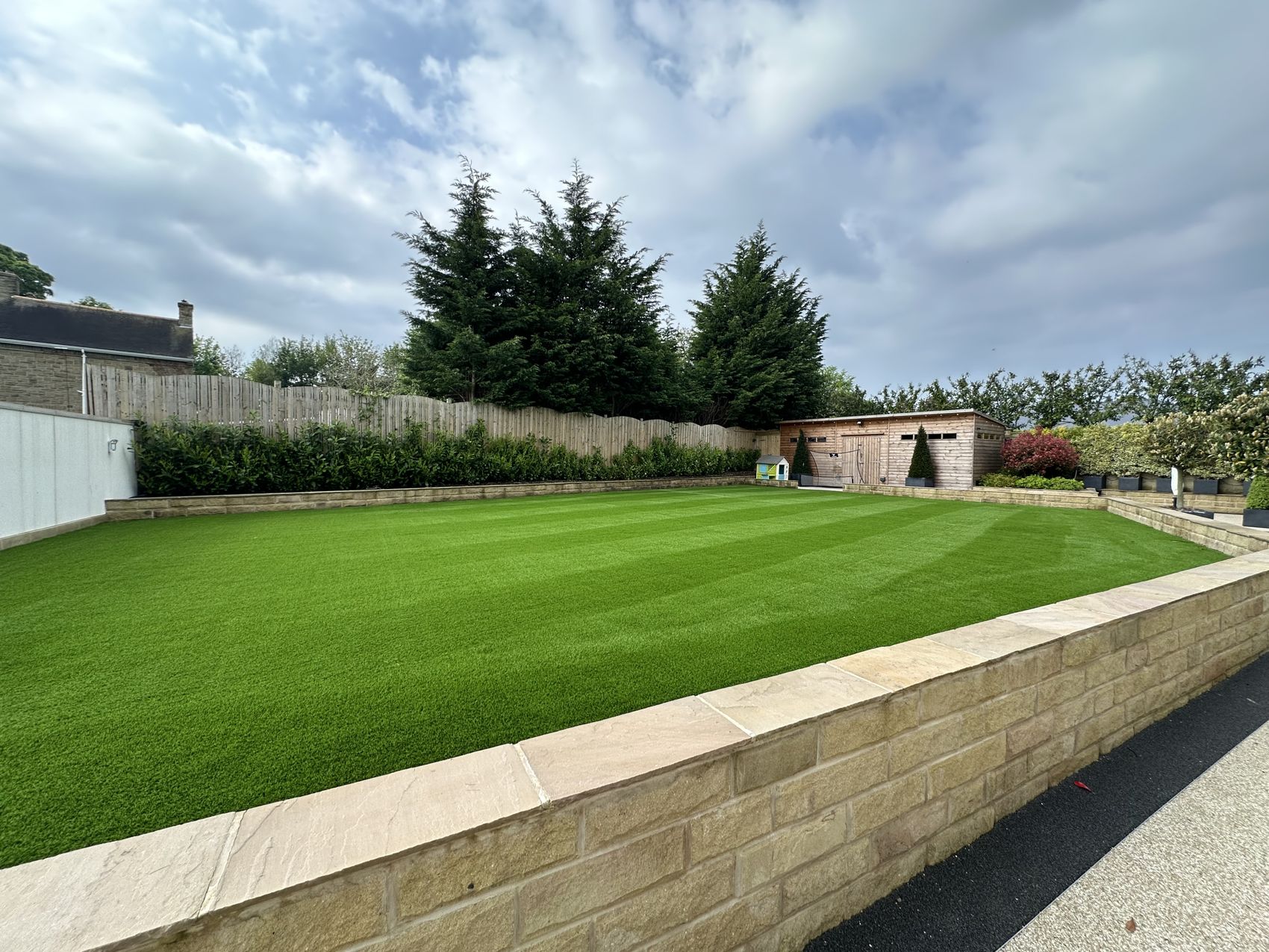 Striped artificial lawn with stone edging